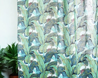 Peut inclure: Un rideau blanc transparent avec un imprimé tropical de feuilles de bananier dans des tons de vert, bleu et marron.
