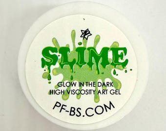 May include: A white container with a green label that reads "SLIME" in a dripping font. The label also says "GLOW IN THE DARK HIGH VISCOSITY ART GEL" and "PF-BS.COM". The slime appears to be a bright green color.