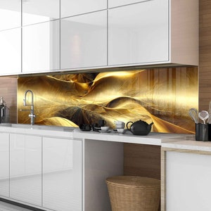Könnte beinhalten: Eine moderne Küche mit weißen Schränken und einer goldenen abstrakten Rückwand. Die Rückwand ist aus Glas und zeigt ein wirbelndes Muster in Gold und Schwarz.