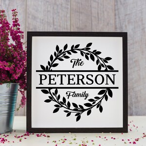 May include: Black and white sign with a wreath of leaves around the text "The Peterson Family".