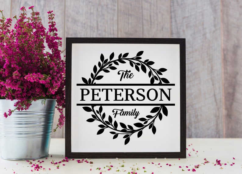 May include: Black and white sign with a wreath of leaves around the text "The Peterson Family".