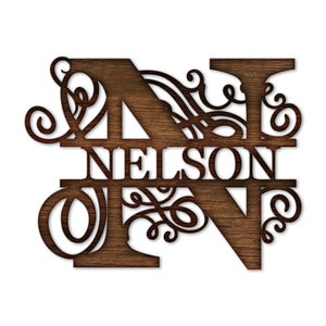 K&ouml;nnte beinhalten: Ein Holzschild mit dem Buchstaben N und dem Namen "NELSON" in einer dekorativen Schriftart. Der Buchstabe N ist von kunstvollen Schn&ouml;rkeln umgeben.