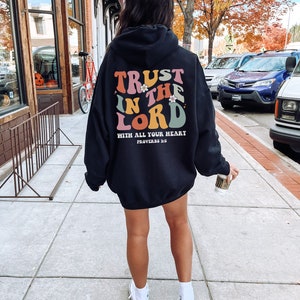 May include: Black hooded sweatshirt with a colorful graphic that says "Trust in the Lord with all your heart, Proverbs 3:5".