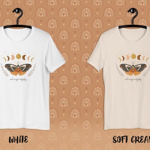 K&ouml;nnte beinhalten: Zwei T-Shirts mit einem Schmetterlings- und Mondphasen-Motiv. Der Text auf dem Shirt lautet "and magic everything". Die Shirts sind in Wei&szlig; und Creme erh&auml;ltlich.