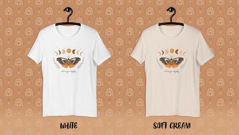 K&ouml;nnte beinhalten: Zwei T-Shirts mit einem Schmetterlings- und Mondphasen-Motiv. Der Text auf dem Shirt lautet "and magic everything". Die Shirts sind in Wei&szlig; und Creme erh&auml;ltlich.