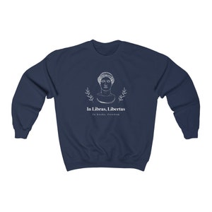 May include: Navy blue sweatshirt with a white graphic of a woman's bust with laurel branches and the text "In Libras, Libertas" and "In books, freedom".