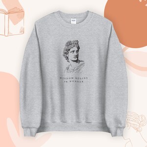 May include: Gray sweatshirt with a black and white illustration of a bust of a man with the text "Wisdom begins in wonder".