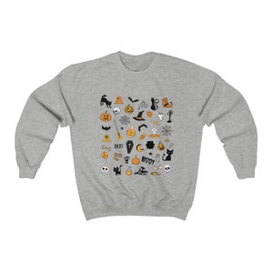May include: A gray sweatshirt with a Halloween-themed design featuring a variety of black and orange icons, including pumpkins, bats, ghosts, witches, and skulls.