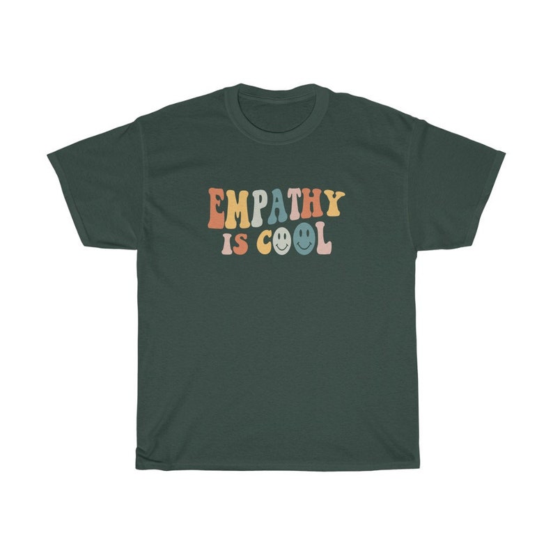 May include: A dark green t-shirt with the text "EMPATHY IS COOL" in rainbow colours with smiley faces.