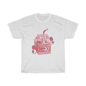 Puede incluir: Camiseta blanca con una ilustraci&oacute;n de dibujos animados rosa de un cart&oacute;n de leche con una pajita, fresas y ojos. El cart&oacute;n dice "Full Milk".