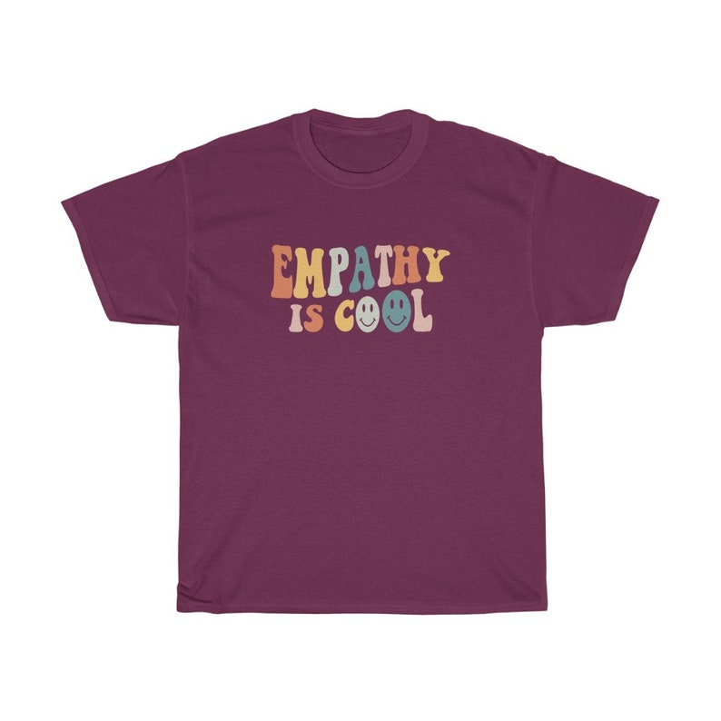 May include: A maroon t-shirt with the text "EMPATHY IS COOL" in rainbow colours with smiley faces.