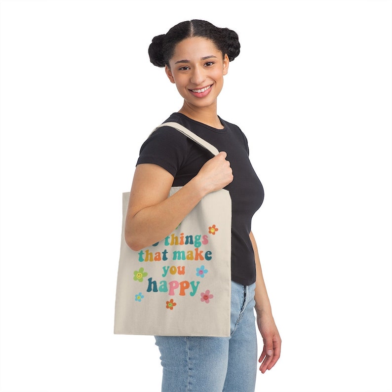 May include: A beige tote bag with the text "Do things that make you happy" in colorful letters and flowers around the text.
