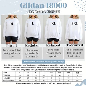 May include: A size chart for Gildan 18000 Unisex Crewneck Sweatshirts. The chart shows the different sizes available, from S to 5XL, and the corresponding measurements in inches for width, length, and sleeve length. The chart also includes a description of the fit for each size: Fitted, Regular, Relaxed, and Oversized. The model normally wears a Large.