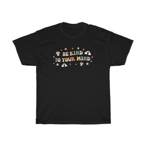 Puede incluir: Camiseta negra con un gr&aacute;fico colorido que dice "Be Kind To Your Mind". El gr&aacute;fico incluye arco&iacute;ris, estrellas y hongos.