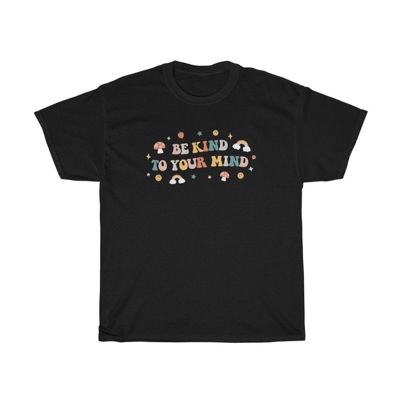 Puede incluir: Camiseta negra con un gr&aacute;fico colorido que dice "Be Kind To Your Mind". El gr&aacute;fico incluye arco&iacute;ris, estrellas y hongos.