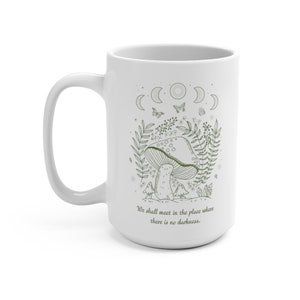 May include: White ceramic mug with a green line drawing of a mushroom, leaves, and butterflies. The text "We shall meet in the place where there is no darkness." is printed on the mug.