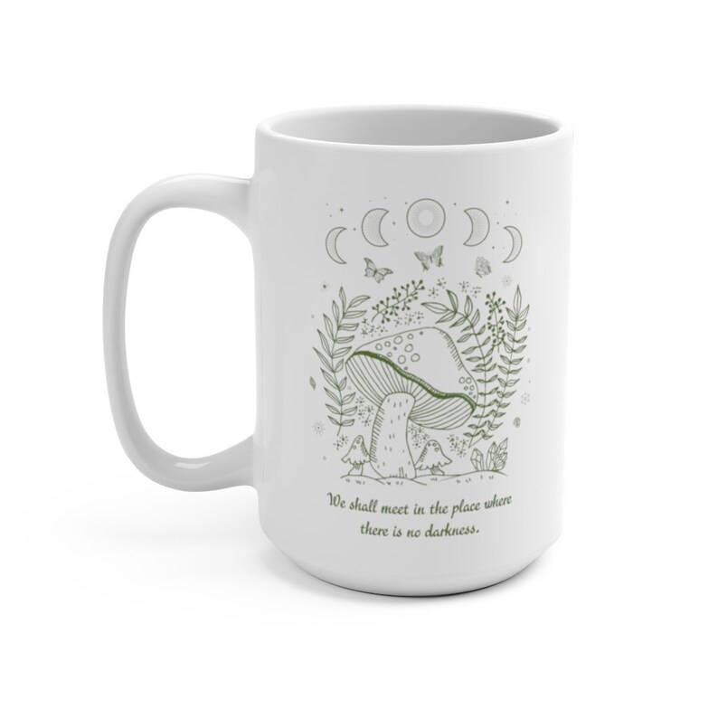 May include: White ceramic mug with a green line drawing of a mushroom, leaves, and butterflies. The text "We shall meet in the place where there is no darkness." is printed on the mug.