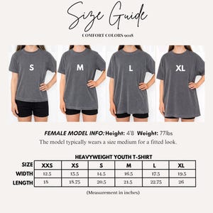 May include: A size guide for Comfort Colors 9018 heavyweight youth t-shirts. The image displays four charcoal grey t-shirts labeled S, M, L, and XL, alongside a table listing widths and lengths in inches for sizes XXS through XL, plus model info.
