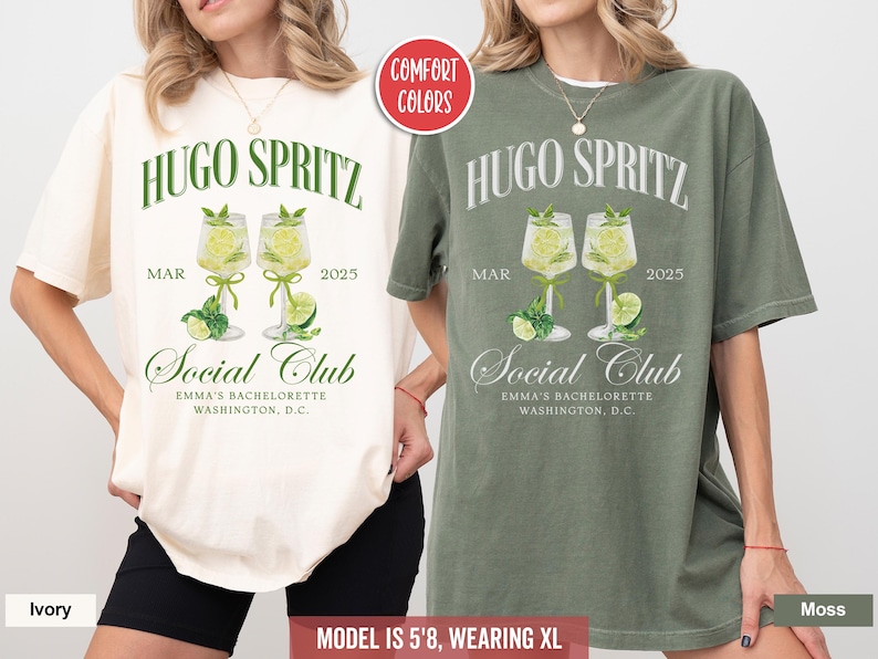May include: Two oversized t-shirts with a green and white design. The shirts feature the text "Hugo Spritz" and "Social Club" with a graphic of two glasses of a cocktail. The shirts are available in ivory and moss.