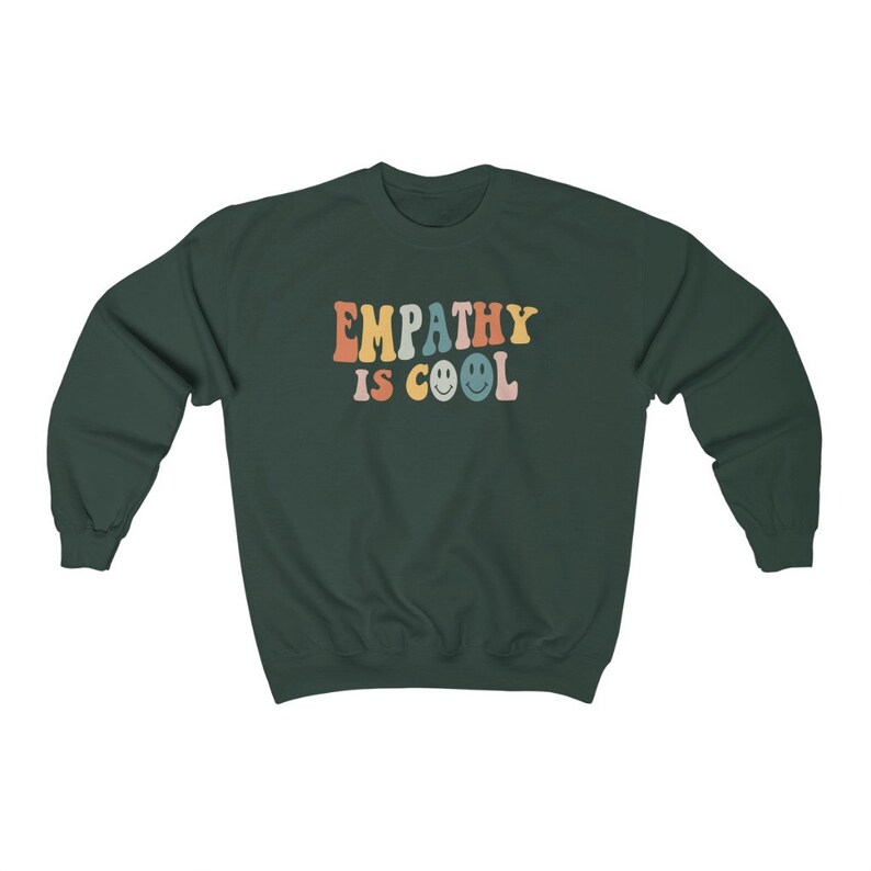 May include: A dark green sweatshirt with the text "EMPATHY IS COOL" in rainbow colors with smiley faces.