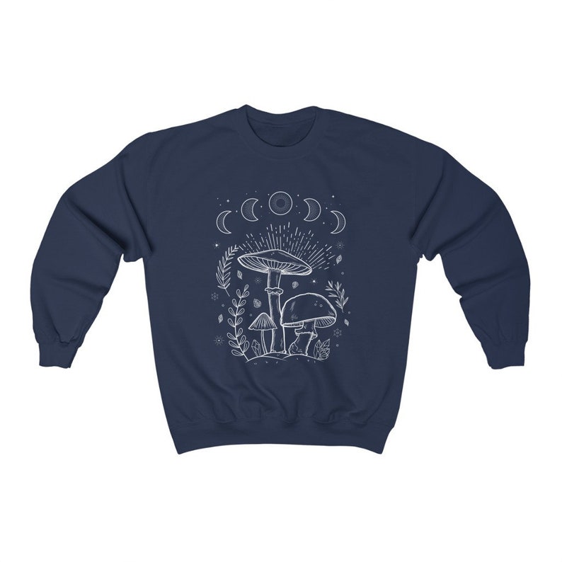 May include: Navy blue sweatshirt featuring a white outline of mushrooms and a crescent moon design. The text "Shroom Queens" is printed on the sweatshirt.