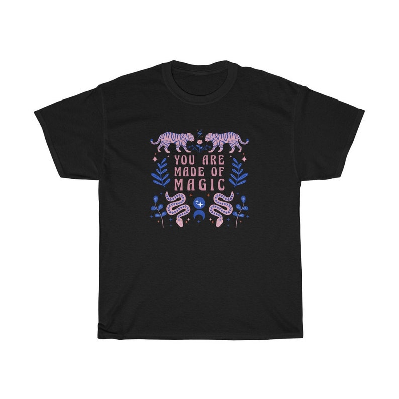 May include: Black t-shirt with a pink and blue design featuring tigers, snakes, and stars. The text "You are made of magic" is printed on the shirt.