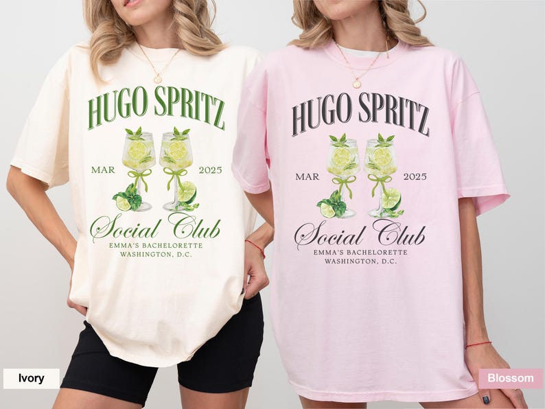 May include: Two white t-shirts with a graphic design of two glasses of Hugo Spritz, a cocktail, with the text "Hugo Spritz" and "Social Club" printed on the front. The text "MAR 2025" is printed below the glasses. The t-shirts are available in ivory and blossom colors.