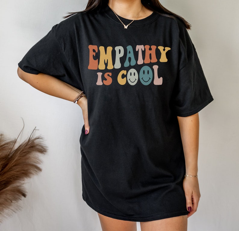 May include: Black oversized t-shirt with the text "EMPATHY IS COOL" in rainbow colours with smiley faces.