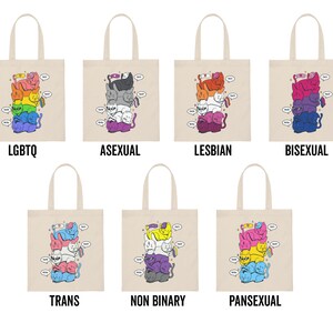 K&ouml;nnte beinhalten: Sieben beige Tragetaschen, jede mit einer Grafik eines vertikalen Stapels aus f&uuml;nf Cartoon-Katzen. Die Katzen sind in verschiedenen Pride-Flaggen-Mustern gef&auml;rbt und halten kleine Flaggen sowie Sprechblasen mit dem Text meow, this und that.