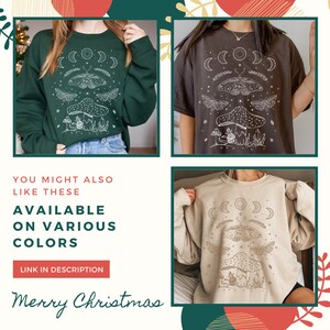 May include: Three sweatshirts with a white graphic design of a mushroom, moth, and crescent moons. The sweatshirts are green, brown, and beige.