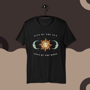 May include: Black t-shirt with a sun and moon graphic and the text "Live by the sun, love by the moon".