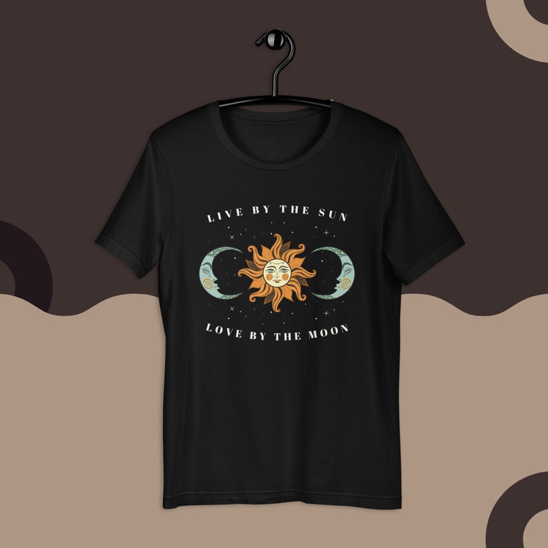 May include: Black t-shirt with a sun and moon graphic and the text "Live by the sun, love by the moon".