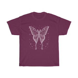 May include: A maroon t-shirt with a white outline of a butterfly with stars and other celestial bodies around it.
