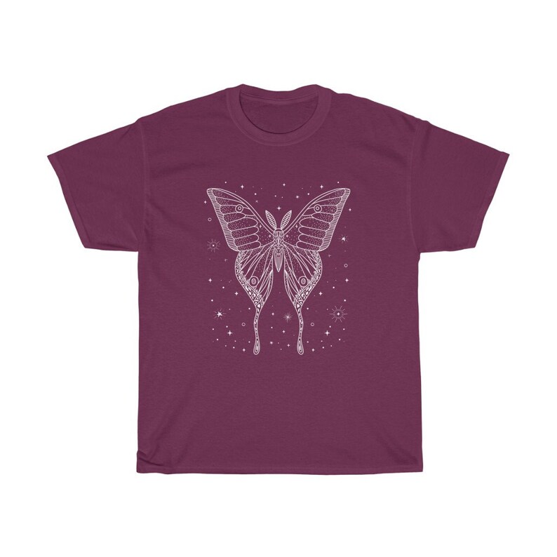 May include: A maroon t-shirt with a white outline of a butterfly with stars and other celestial bodies around it.