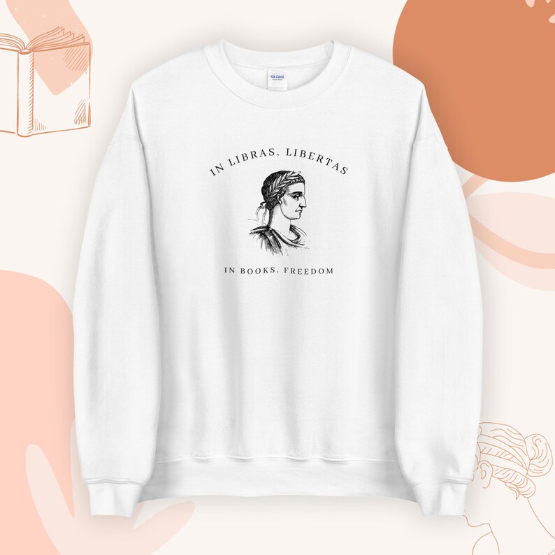 May include: White sweatshirt with a black and white illustration of a woman's head and the text "In Libras, Libertas. In Books, Freedom."
