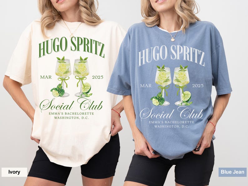 May include: Two t-shirts with a graphic design of two glasses of Hugo Spritz, with the text "Hugo Spritz" and "Social Club" on the front. The t-shirts are in ivory and blue jean colors.