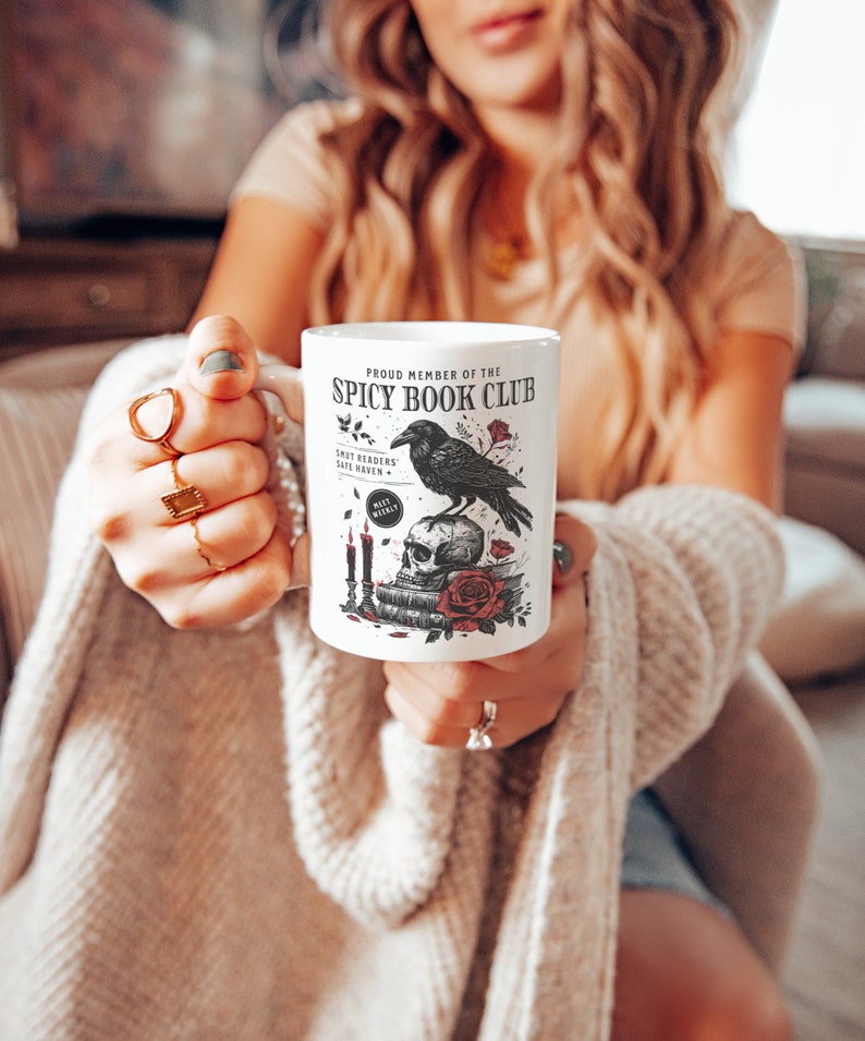 Puede incluir: Taza de cer&aacute;mica blanca con un dise&ntilde;o de cuervo negro, calavera y rosas. La taza dice "Proud Member of the Spicy Book Club".