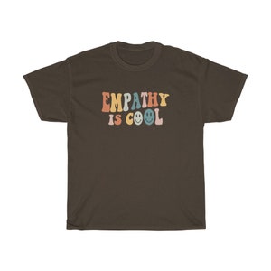 May include: A brown t-shirt with the text "EMPATHY IS COOL" in rainbow colours with smiley faces.