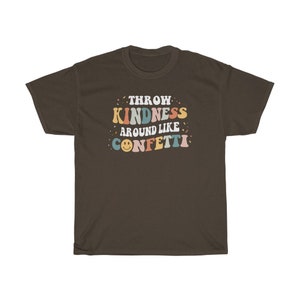May include: A brown t-shirt featuring the text "Throw Kindness Around Like Confetti" in colourful retro lettering. The text is surrounded by confetti and a smiley face.