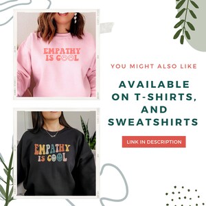 May include: Two sweatshirts with the text "Empathy is Cool" in different colour schemes. The top sweatshirt is pink with red text and a smiley face. The bottom sweatshirt is black with rainbow text and a smiley face.