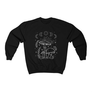 May include: Black sweatshirt featuring a white outline of mushrooms and a crescent moon design.