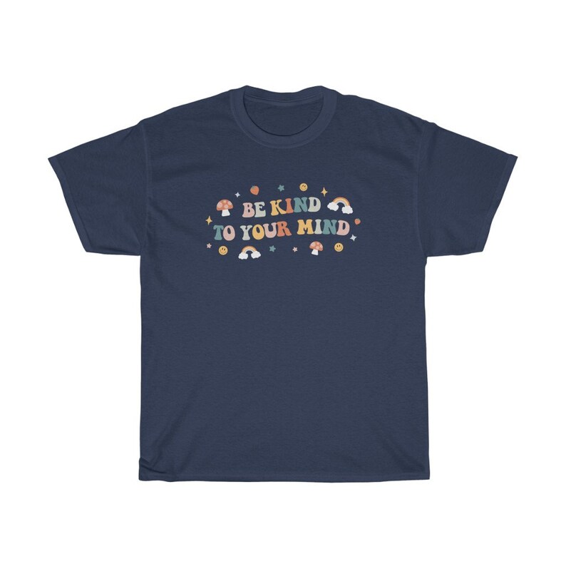 Puede incluir: Camiseta azul marino con un gr&aacute;fico colorido que dice "S&eacute; amable con tu mente". El gr&aacute;fico incluye hongos, arco&iacute;ris y estrellas.