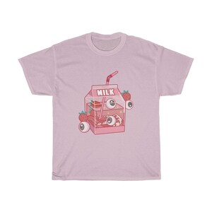 Puede incluir: Camiseta rosa con una ilustraci&oacute;n de dibujos animados de una caja de leche llena de ojos, fresas y una pajita. La caja dice "Full Milk" en la parte superior.