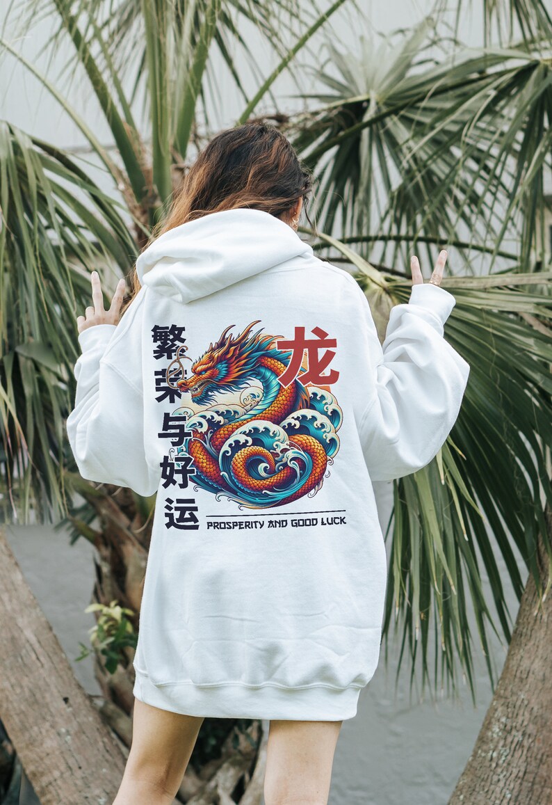 May include: White hoodie with a colorful dragon graphic on the back. The dragon is surrounded by waves and the text "Prosperity and Good Luck" is printed below. The hoodie also features Chinese characters in red.