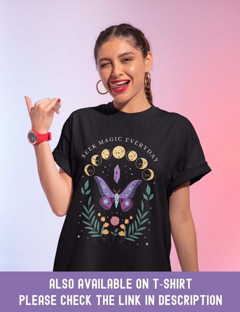May include: Black t-shirt with a graphic design featuring a purple butterfly, a crystal, and the text "SEEK MAGIC EVERYDAY" in a circle around the design.