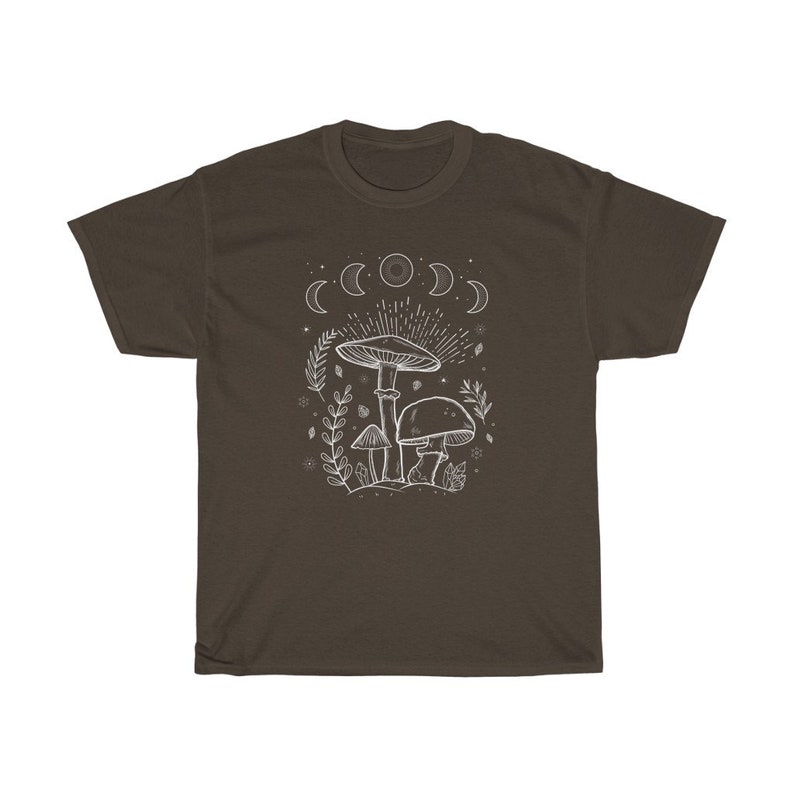 May include: A brown t-shirt featuring a white outline of mushrooms and a crescent moon design. The design depicts three mushrooms with a moon phase above them.