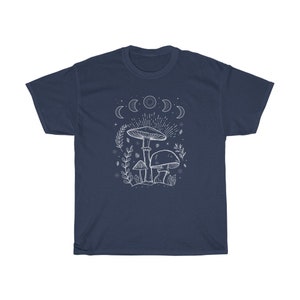May include: Navy blue t-shirt featuring a white outline of mushrooms and a crescent moon design. The text "Shroom Queens" is printed on the shirt.