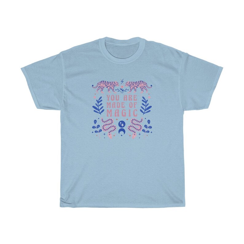 May include: Light blue t-shirt with a pink and blue graphic design featuring tigers, snakes, and the text "You are made of magic".