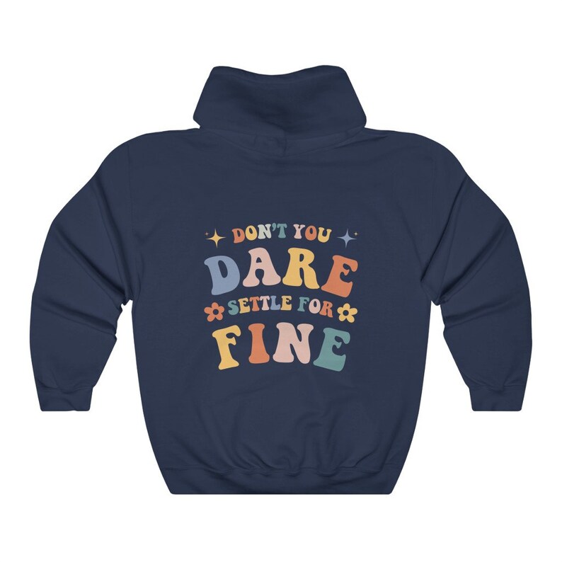 Puede incluir: Sudadera con capucha azul marino con el texto "Don't you dare settle for fine" en letras de colores con estrellas y flores.