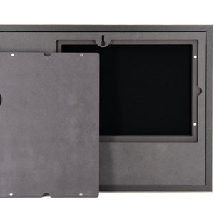 Pode incluir: Uma moldura de imagem preta com um painel frontal remov&iacute;vel. O painel est&aacute; aberto, revelando um interior preto.